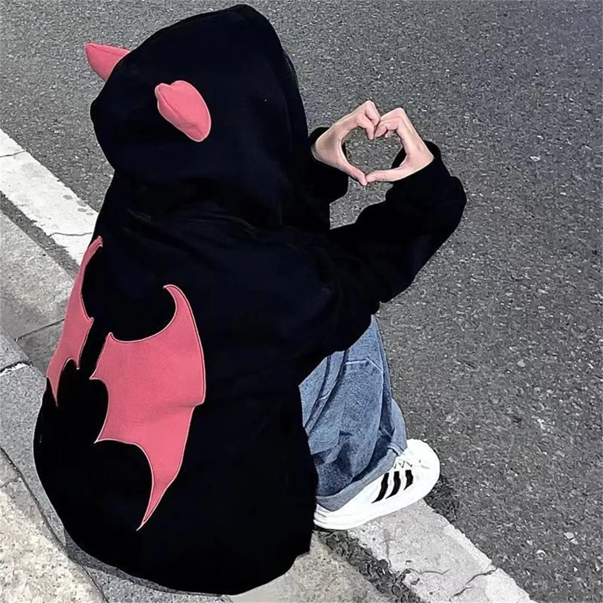 Evil Horns Hoodies Women featuring bat wing design on the back in a casual setting